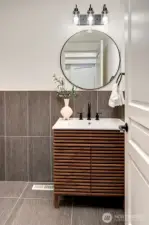 Main level guest bath with new designer vanity, modern tiling and lighting!