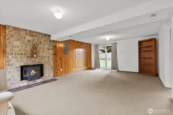 Lower-level rec room with masonry fireplace and backyard access.