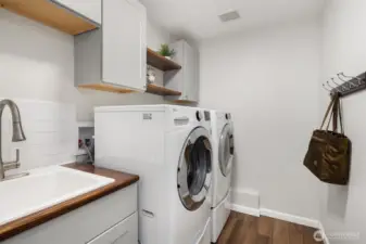 The remodeled and large laundry room w/new flooring, cabs and counters.