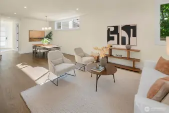 Open concept dining and living room area on the main floor. The main entrance has extra "mudroom" space and there's a powder room just behind the dining room area in this photo.