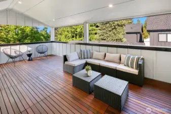 The covered deck on the top level of the home has beautiful wood decking. The parapet wall creates privacy.