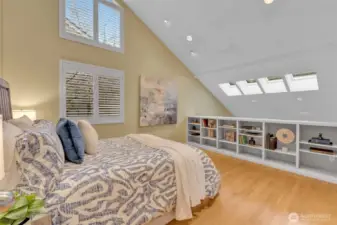 Upstairs is the primary bedroom, offering vaulted ceiling, built-in bookcase, hardwood floors. Want to close off open loft? Owner has custom glass cut for the space and ready to install!
