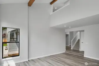 Soaring ceilings highlighted by wood beams create a striking architectural feature in the living room.