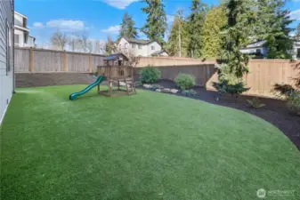 beautifully designed low-maintenance yard with turf play area