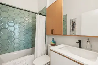 Similar in design/style, the upper level bathroom has a tub.