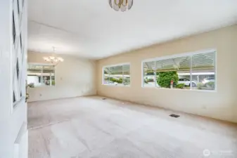 An enormous living room and connected dining area have huge windows providing tons of natural light!