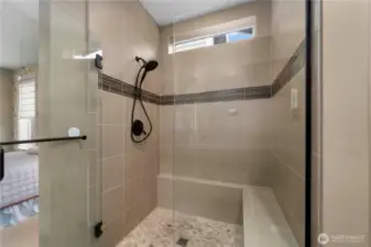 Fully tiled shower with a bench and a convenient niche.