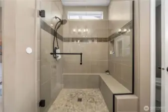Fully tiled shower with a bench and a convenient niche.