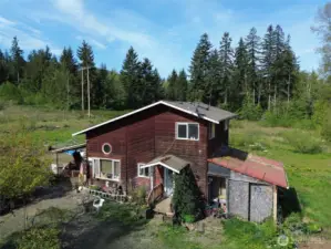 Country living yet ten minutes from town and the beach. Front of the house with land cleared around it.