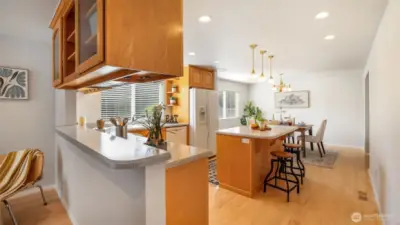 Warm wood cabinetry and generous counters create a functional kitchen space.