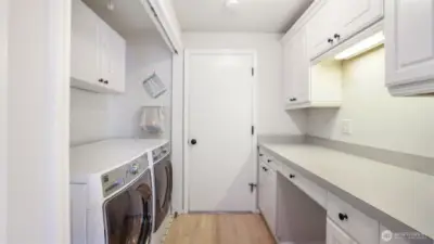 Spacious laundry room with built-in cabinets and folding counter.