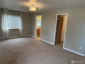 View of the Primary Suite showing doorways to the Ensuite Bath and Walk-in Closet.