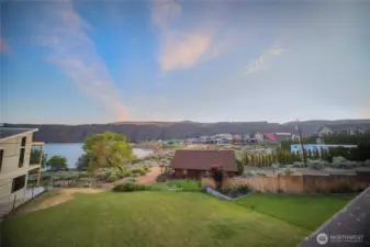 Large lawn on river facing side of house has sprinkler system.