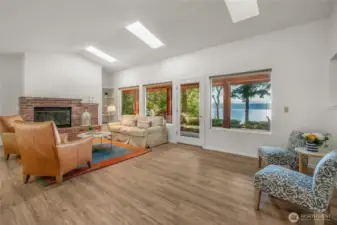 Enjoy views year round in spacious living room with vaulted ceilings, skylights and wood burning fireplace. New flooring and paint.