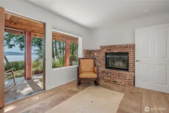 Peaceful setting in the office/den with wood burning fireplace. Take in the water and mountain views.
