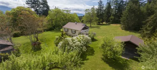 Your charming Farmhouse retreat awaits. With acres of mature landscape and original restored Farmstead cabin and outbuildings.