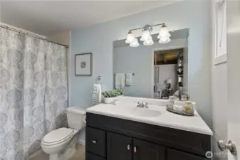 bathroom with modern updates, including sleek vanity and tiled surround.