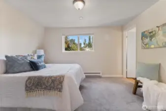 Peaceful primary bedroom with large windows, soft neutral tones, and ample room for a queen-size bed.