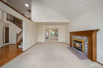 Upon entering, this formal living room is to the right. Gas Fireplace will keep you cozy during the winter. Notice the vaulted ceilings - and the Solar Tubes (one visible here) keep the upper level landing bright.