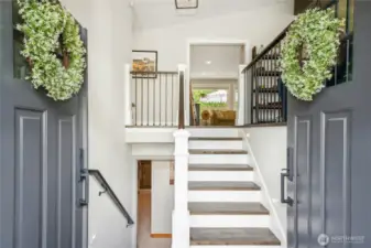 Hardwood floors throughout entry, stairs, living room, family room, and hallway.