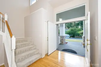 Entryway with double front door and maple hardwood floors.