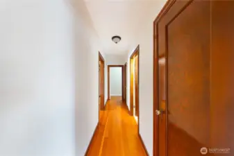 Hallway with entrances to main floor full bath, primary hallway and office.