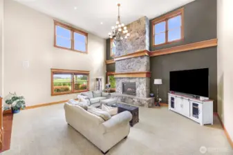 Formal living room boasts a floor to ceiling and massive stone fireplace
