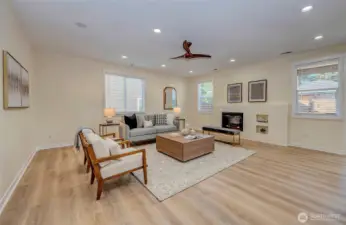 Family room with electric fireplace and windows overlooking the yard