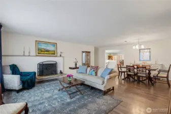 Light filled living room featuring cozy fireplace and timeless hardwoods.