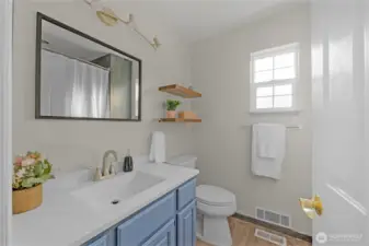 Freshly painted guest bathroom with new fixtures and shelving.