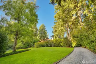 Rolling lawn down to Chambers Creek as you approach the home.