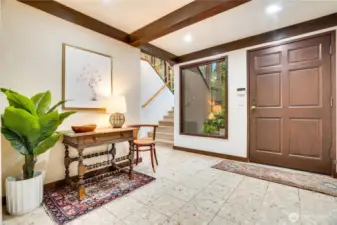 Main entry door.  Stone floor with natural light from the stairwell into the large foyer.