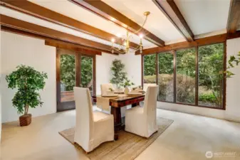 Dining room with green views outside punctuated with a gold crystal chandelier.