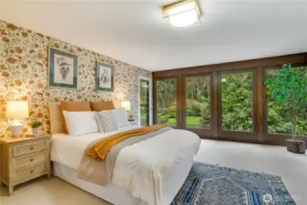 Floral wallpaper continues the lush landscape from the outside thru window panels.