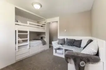 Third bedroom with built in bunkbeds and bench.