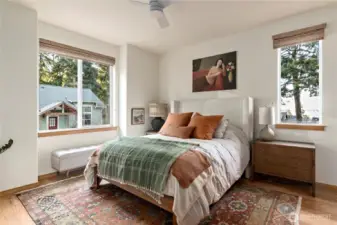 Primary bedroom on main, beautifully designed with ample closet space and plenty of light. Custom window blinds and solid wood floors are some of the luxuries.