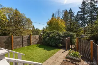 You will LOVE this covered, south-facing  porch! Ready for 4-season coffee sippin'!  Fully-fenced yard, veggie patch, low  maintence turf.