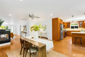Love the connection between dining room  and kitchen. Cozy 2-sided gas fireplace  anchors the space.