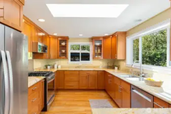This is a serious (and seriously inspiring!)  kitchen for the home chef: abundant  cabinetry, gas range, wonderful natural light  (LOVE the skylight), and wonderful space to  spread out and create your everyday home  cooking masterpieces! Oh, yes, a wine  fridge for the celebrations.
