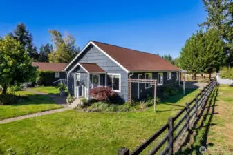 View of front of the home, with beautiful wooden flower garden arch.
