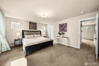 Spacious light filled primary bedroom with sitting area, en suite bath and two walk in closets.