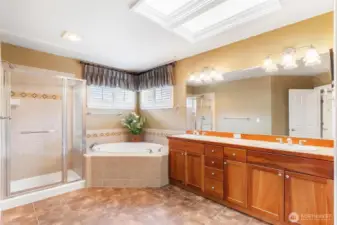 Primary bath, with corner soaking bathtub, skylight window, double vanity with counter space and your own linen closet.