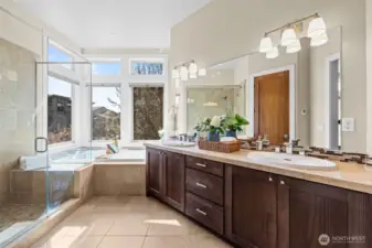 Beautifully appointed Primary Bathroom features Dual Sinks, Soaking Tub, Oversized Shower with Glass Doors, Heated Tile Flooring, and a separate toilet room.