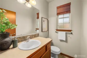 Main-floor half bath with beautiful stone tile backsplash