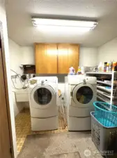 Laundry room w/ folding area, a closet, sink and water heater.