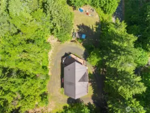 Bird’s-eye view shows the home nestled among mature trees with a functional wrap-around driveway.
