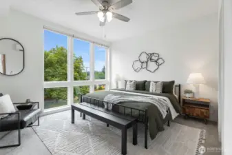 Primary bedroom with floor-to-ceiling windows & A/C to keep you cool on those Summer days.
