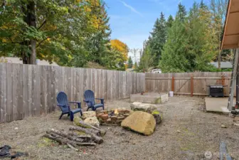 Cozy fire pit and gardening area, currently gravel, easy to maintain