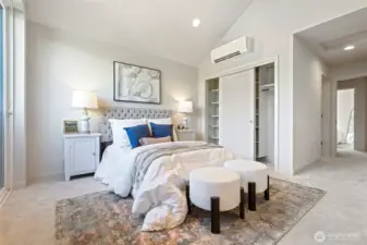 A full view of the spacious primary bedroom, complete with dual closets and ductless mini-split for personalized comfort year-round.