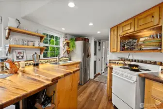 Well-designed kitchen with wood cabinetry and large windows that bring in abundant natural light.